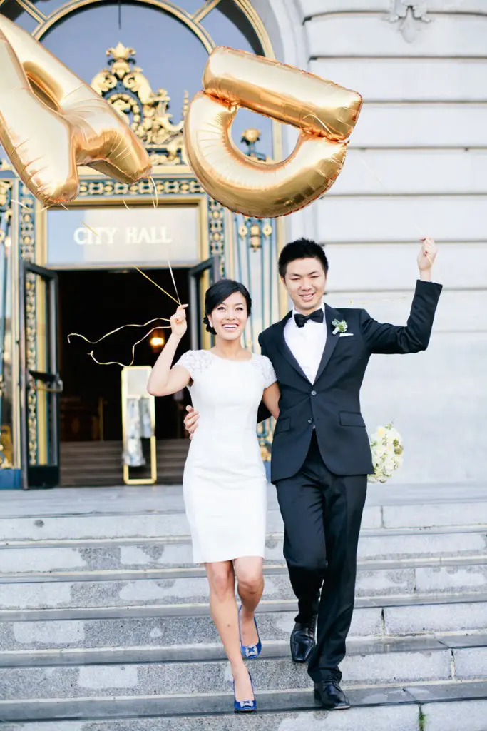 bride-and-groom-holding-giant-gold-letter-balloons-after-ceremony