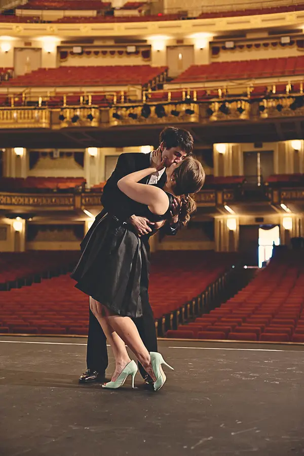 couple kissing on stage in front of the lights at the orpheum 