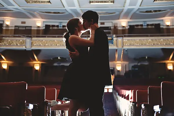 couple kissing in front of the lights at the orpheum 