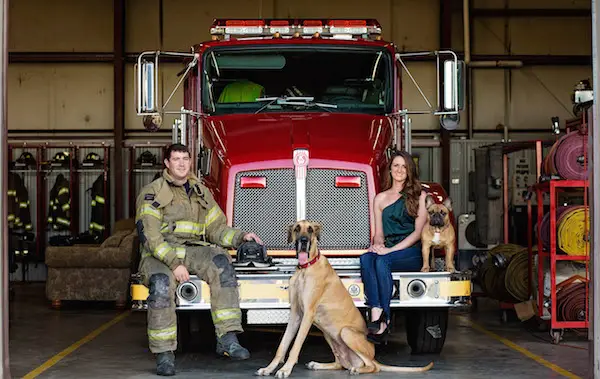 Christine & Zac sitting on a fire struck in Fire Station Engagement Photos - photo by Crystal Brisco Photography  