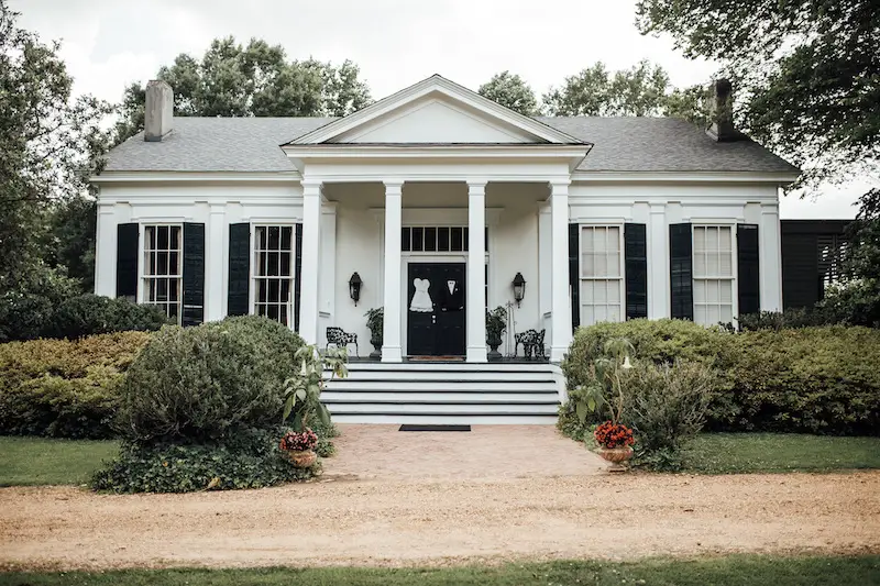 planter's cottage at Hedge Farms wedding venue in Red Banks, MS with dress and suit on doors photo by The Warmth Around You