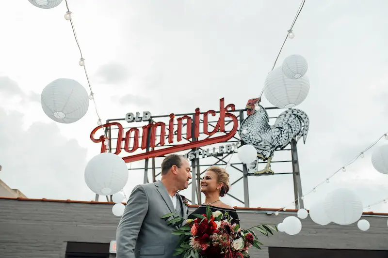 Old-Dominick-Distillery-Memphis-Wedding-Venue-rooftop-terrace-during-the-day-with-lanterns-and-lights-strung-up-with-the-couple-in-the-center-photo-by-The-Warmth-Around-Us
