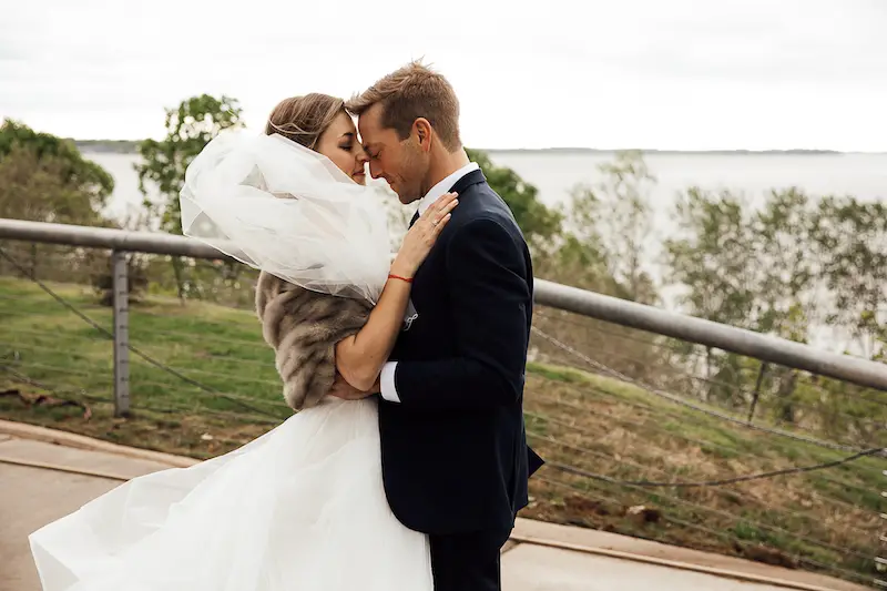 couple embracing in front of the Mississippi River at Metal Museum Memphis wedding photo by The Warmth Around You