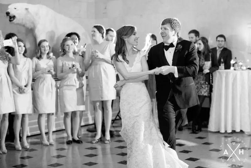 Inside the eclectic museum venue with displays behind dancin couple at Memphis Pink Palace Wedding - Photo by Amy Hutchinson Photography